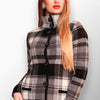 Woman wearing a black and white plaid short coat with a high neck buttoned design.