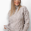 Dina beige cable knit turtleneck sweater.
